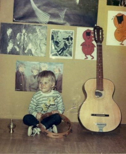 young kurt cobain picture alongside an acoustic guitar