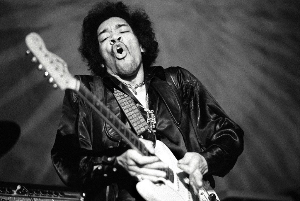 A stylized graphic depiction of Jimi Hendrix, showcasing his signature style and electric charisma, suitable for use as a background.